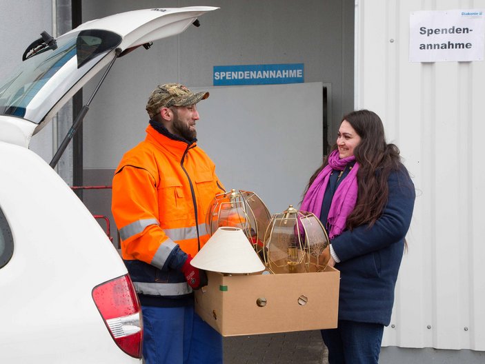 Frau übergibt Ihre Sachspenden an die Diakonie