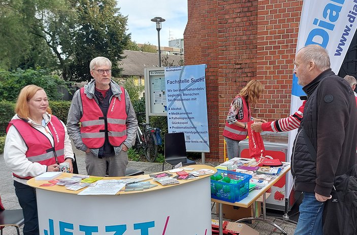 Mitarbeitende der Suchtberatung am Info-Tresen vor der Erlöserkirche