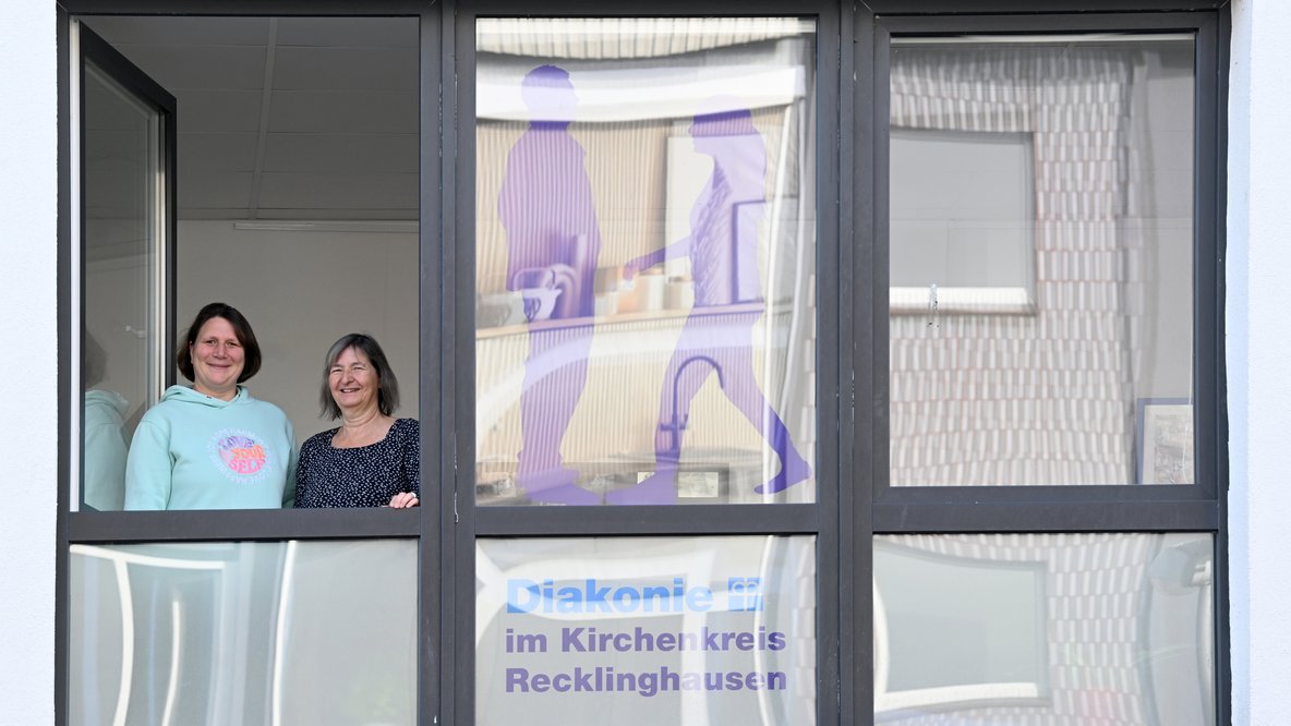 Menschen schauen aus dem Fenster und lächeln in die Kamera
