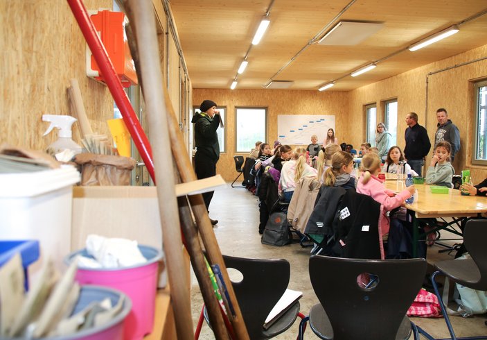 Kindern sitzen in einem Raum und bekommen etwas erzählt