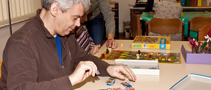 Mann puzzelt am Tisch