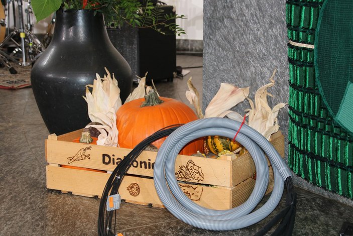 Kürbis und Starkstromkabel in der Diakonie-Holzkiste vor dem Altar