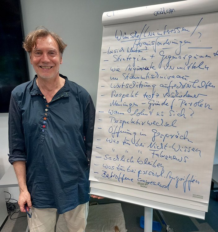 Refernt Jürgen Albrecht neben einem Flip-Chart. 