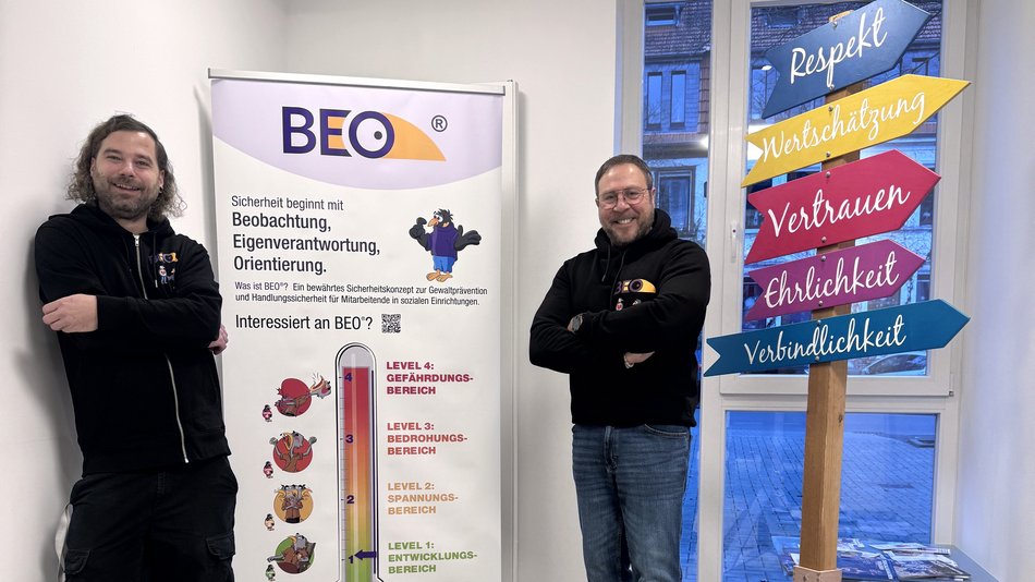 Zwei Personen stehen vor einem BEO-Roll-Up