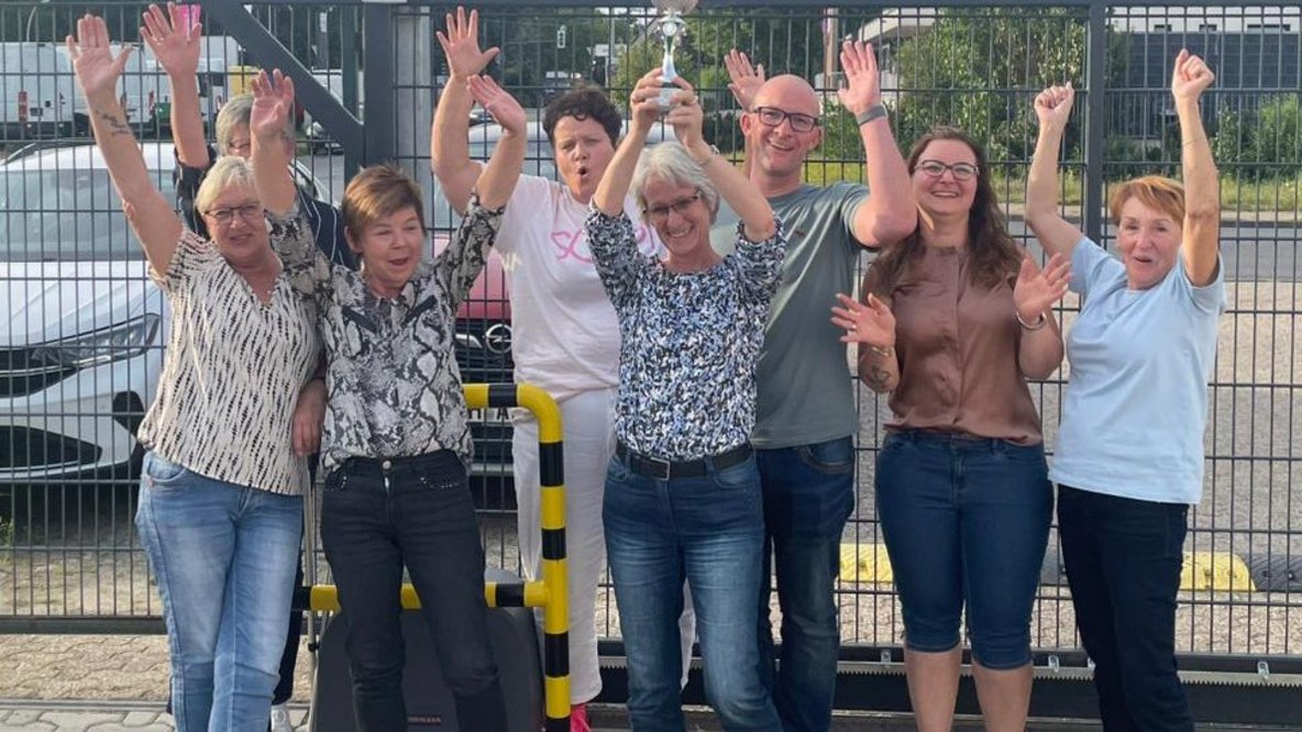 Jubelnde Mitarbeiterinnen, die ihre Arme in die Luft strecken