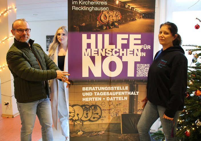 Karl Cielontko, Lena Hartmanns (beide Vonovia) und Vera Wieland (Diakonie) vor dem Plakat "Hilfe für Menschen in Not"