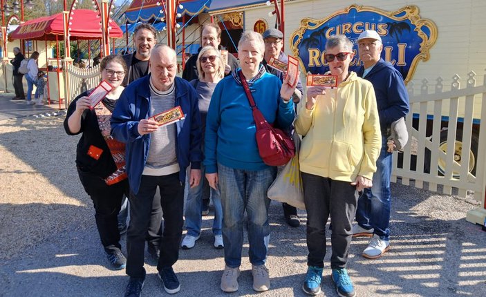 Die Besuchergruppe mit Freikarten vor einem Zirkuswagen von Roncalli