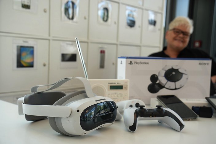 Auf einem Tisch liegen mehrere digitale Dinge wie eine VR-Brille oder ein Controller.