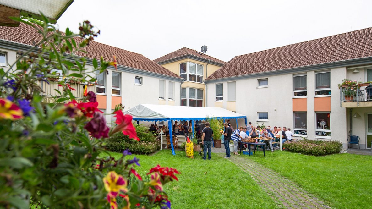 Im Garten des Haus am Schillerpark steht ein Festzelt und viele Menschen sind darunter