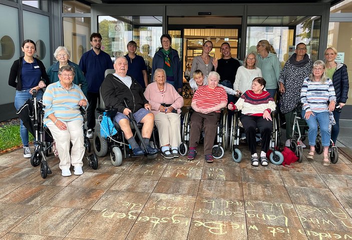 Gruppenbild mit Senior*innen, Rollatoren und Mitarbeiterinnen vor dem Eingang des Matthias-Claudius-Zentrum