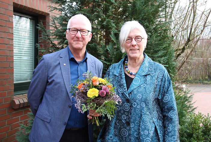 Bernd Langhorst und Marita Heßler mit Blumenstrauß vor der Tagesstätte