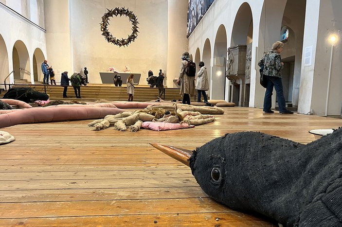 leer stehendes Kirchenschiff aus der Käferperspektive mit großen Stofftieren im Vordergrund