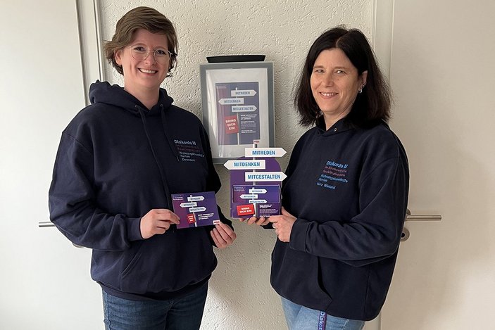 Cosima Nellen und Vera Wieland lächeln mit den Materialien in der Hand