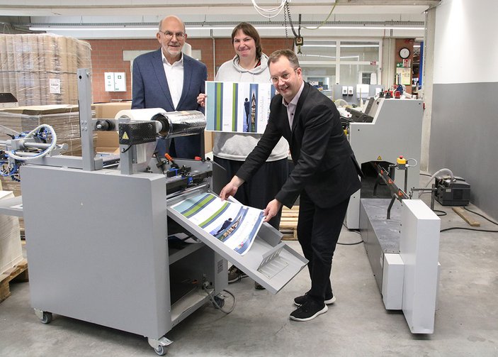 Peter Burkowski, Maria Ernst und Dr. Dietmar Kehlbreier an einem Drucker