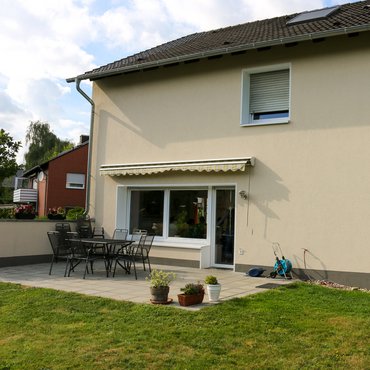 Außenansicht eines Wohnhauses mit Garten und Terrasse