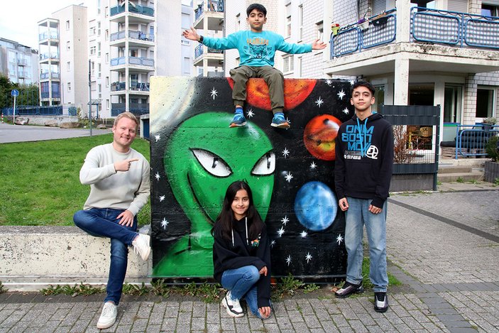 Gruppenbild vor der besprayten Wand