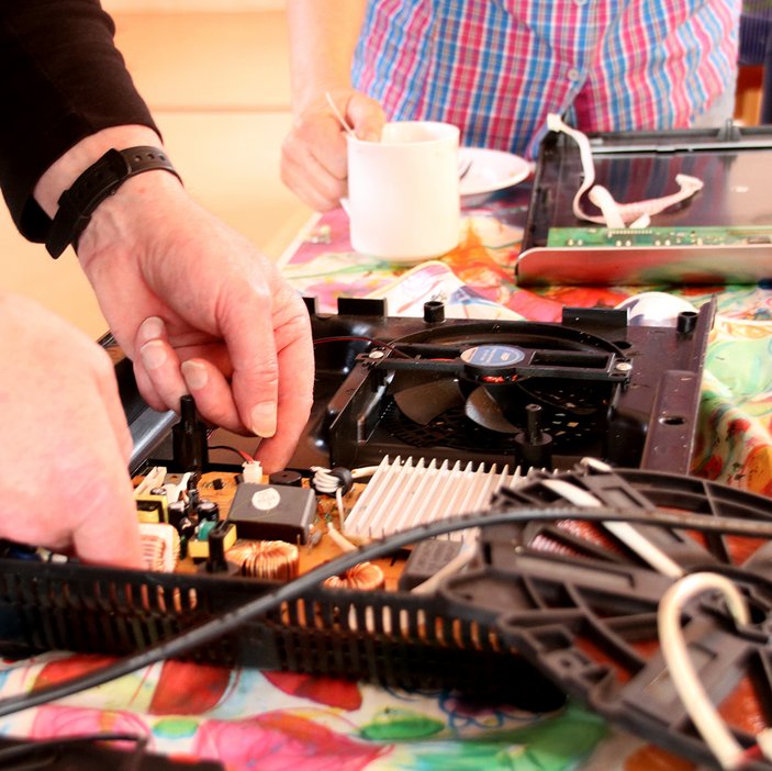 zwei Hände, die an einem Plattenspieler reparieren